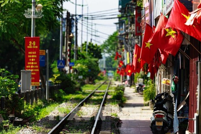 Dọc tuyến đường sắt đi qua khu dân cư, những lá cờ Tổ quốc nối tiếp nhau trước mỗi ngôi nhà, cho thấy không khí Quốc khánh không chỉ hiện diện tại những quảng trường, đại lộ mà còn đi vào từng góc nhỏ của thành phố. Ảnh: Phạm Tuấn Anh - TTXVN