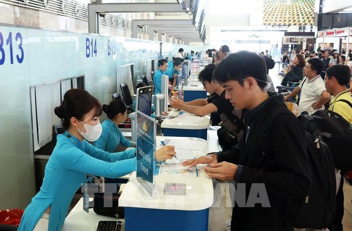Hành khách làm thủ tục check-in tại quầy của Vietnam Airlines, sáng 28/8. Ảnh: Quốc Khánh - TTXVN