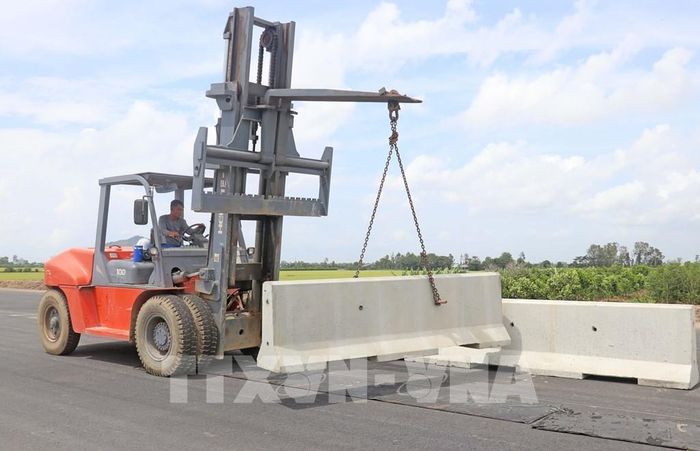 Công nhân Tổng Công ty Xây dựng Trường Sơn lắp đặt, hoàn thiện hệ thống dải phân cách. Ảnh: Công Mạo-TTXVN