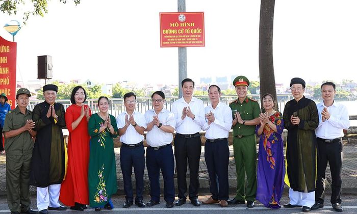  Các đại biểu và người dân tổ dân phố Thị Cầu 3 kéo băng khánh thành "Đường cờ Tổ quốc".  