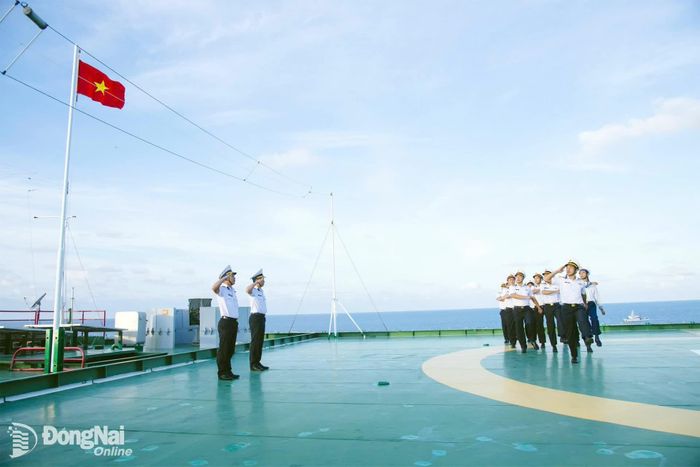 Cán bộ, chiến sĩ duyệt đội ngũ dưới lá cờ Tổ quốc.
