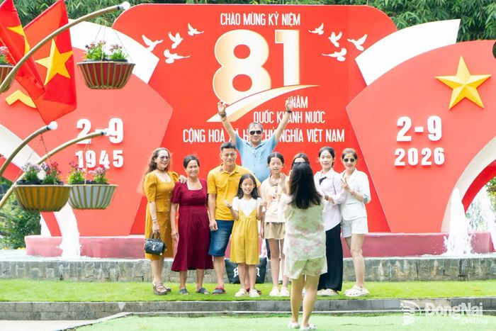 Du khách check in khu vực trang trí mừng lễ 2-9 tại khu du lịch Suối Mơ. Ảnh: Long Hưng