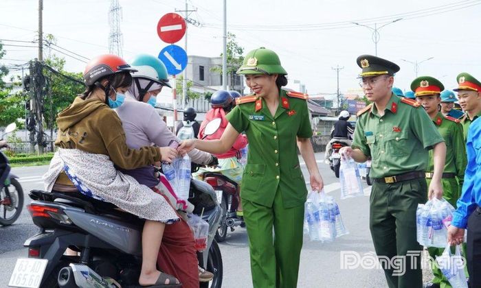 Lực lượng Công an, đoàn viên, thanh niên phát nước suối và khăn lạnh tặng người dân.