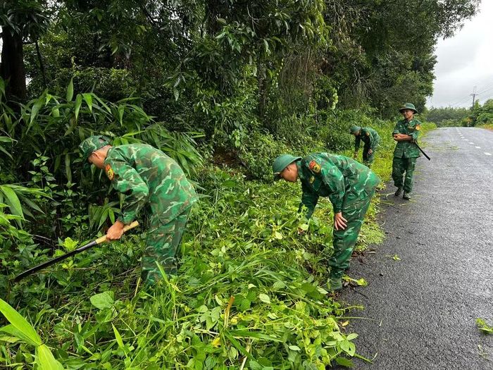  Cán bộ, chiến sĩ Đồn Biên phòng Ia Púch và Tiểu đoàn Huấn luyện-Cơ động dọn vệ sinh tuyến đường giao thông qua thôn Chư Có. Ảnh: ĐVCC 