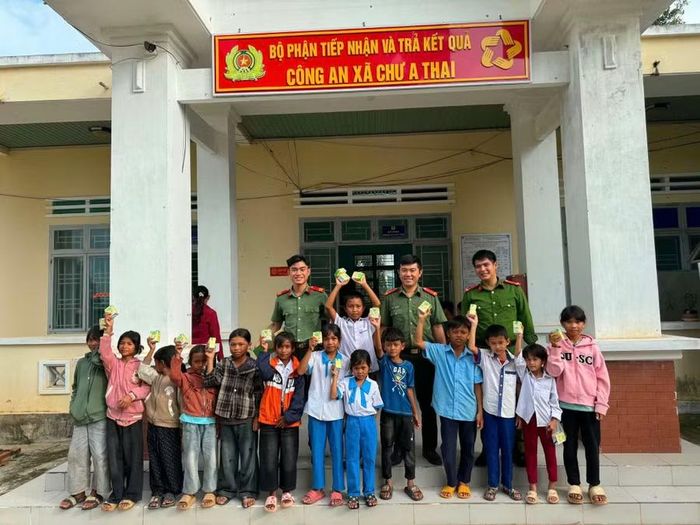  Công an xã Chư A Thai phát sữa cho các em nhỏ đến làm căn cước. Ảnh: Tiến Tống 