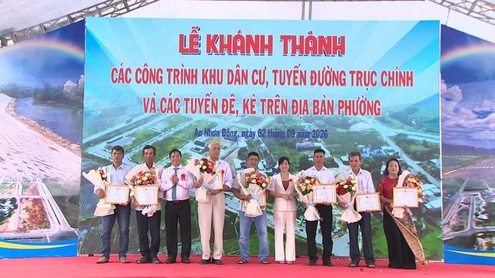  Ông Mai Xuân Tiến (đứng thứ 3 từ trái sang) - Chủ tịch UBND phường An Nhơn Đông trao tặng giấy khen cho 7 hộ gia đình tiêu biểu trong công tác giải phóng mặt bằng. Ảnh: Bảo Long 