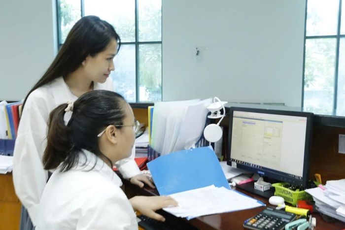 Giao dịch viên Kho bạc Nhà nước khu vực XIV trao đổi nghiệp vụ.