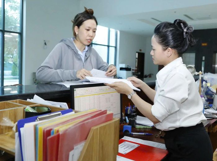 Giao dịch viên Kho bạc Nhà nước khu vực XIV hướng dẫn khách hàng đến giao dịch.
