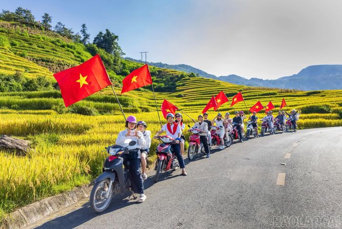 Đoàn du khách mang theo lá cờ đỏ sao vàng đi giữa cung đường hình chữ "S" trong ngày Quốc khánh 2/9, tạo nên hình ảnh đẹp, ấn tượng.