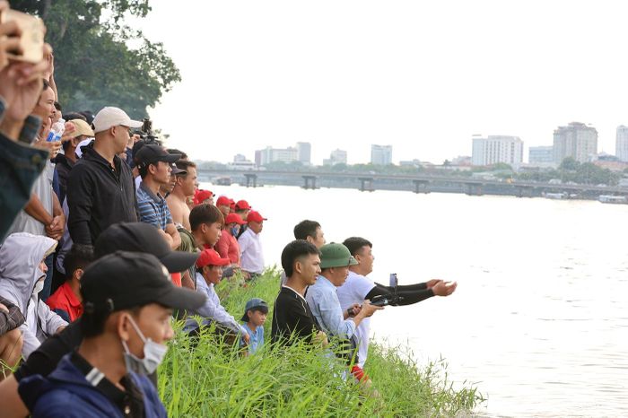 Cổ động viên chăm chú dõi theo ghe đua của đội mình. 
