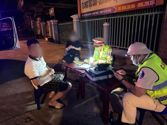 Cán bộ Trạm CSGT Thăng Bình, Phòng CSGT Công an TP Đà Nẵng lập biên bản xử lý trường hợp vi phạm nồng độ cồn tối 1/9.