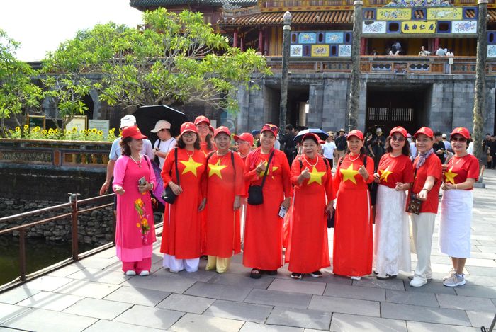 Một nhóm du khách mặc áo cờ đỏ sao vàng tham quan Đại nội Huế.