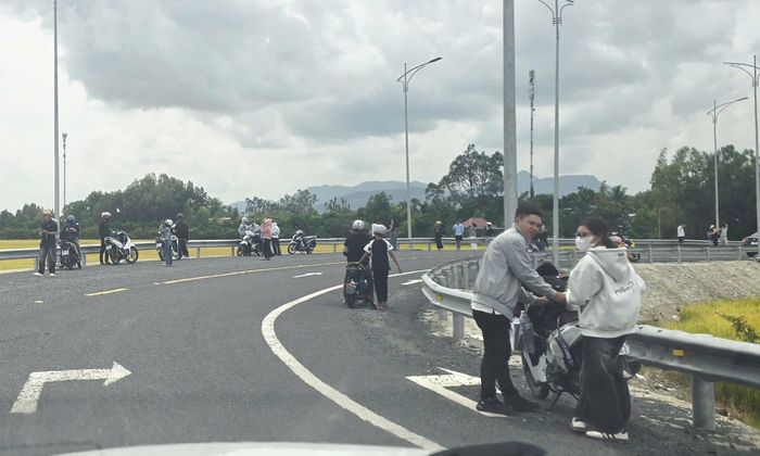Nhiều người dừng xe, đỗ xe ngay đoạn đường cong dưới dốc cầu Cây Me 2 cuối tuyến tránh Tri Tôn để chụp ảnh tiềm ẩn nguy cơ mất an toàn giao thông.
