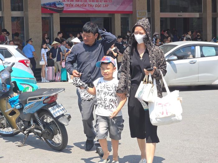 Em bé theo mẹ vội ra về, tránh nắng.