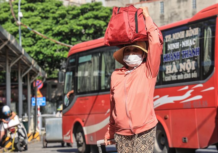 Hành khách trang bị chống nắng kín mít khi trở lại Thủ đô trong tiết trời nắng gắt. 