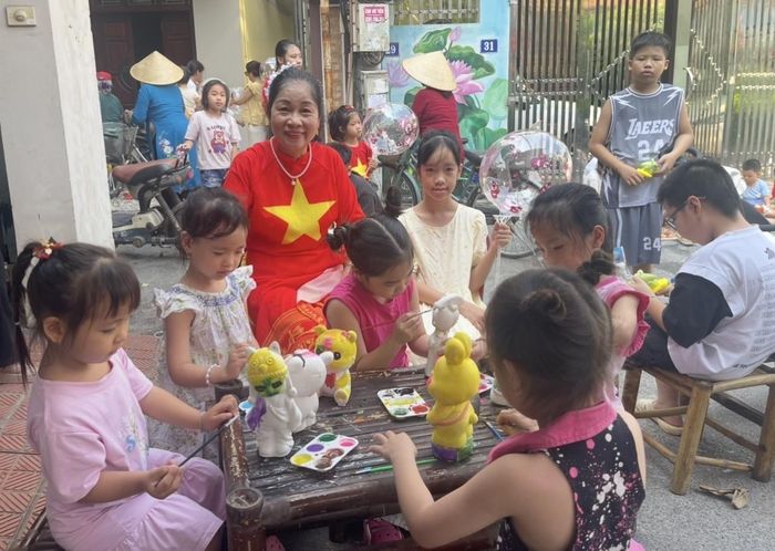 Các em nhỏ hào hứng tham gia hoạt động tô tượng trong không gian sinh hoạt cộng đồng tại Tổ dân phố Chợ.