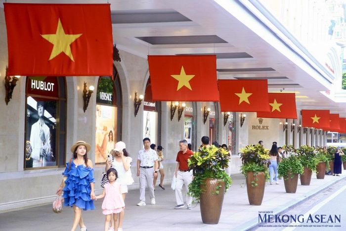 Người dân và du khách dạo phố dưới lá cờ đỏ sao vàng tung bay phấp phới. Ảnh: Trần Trọng/ Mekong ASEAN