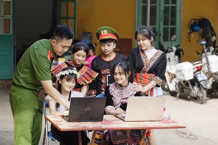 Cán bộ Công an dạy trẻ em vùng cao tìm hiểu kiến thức qua mạng Internet.