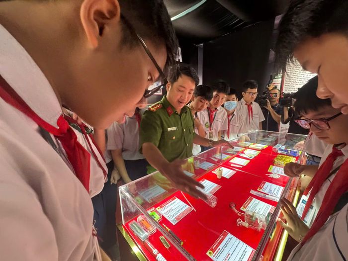 Các em học sinh chăm chú theo dõi trưng bày của mô hình “Điểm giáo dục phòng, chống ma túy” trong trường học tại phường Tân Sơn Hòa.