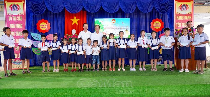 Đồng chí Lê Thanh Triều và đồng chí Lê Hồng Thịnh, chụp ảnh lưu niệm cùng các em nhận học bổng.