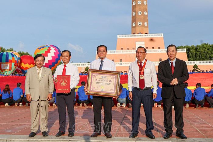 Ông Dương Duy Lâm Viên, Phó Chủ tịch kiêm Tổng Thư ký Trung ương Hội Kỷ lục gia Việt Nam (bìa phải), cùng ông Hà Phước Dũng (bìa trái) trao Bằng Kỷ lục “Lá cờ Tổ quốc bằng vải lớn nhất Việt Nam” cho Phó Chủ tịch UBND tỉnh Ngô Vũ Thăng (giữa); trao quyết định cho đồng chí Nguyễn Quốc Thanh, Giám đốc Sở VH,TT&DL (thứ 2 từ trái sang) và trao Huy hiệu cho ông Lê Văn Dũng, Giám đốc Vườn Quốc gia Mũi Cà Mau.