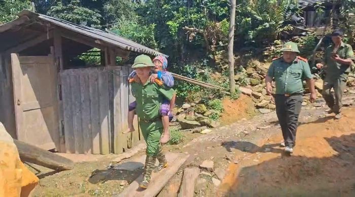 Công an xã Pha Long phối hợp cùng quần chúng nhân dân đưa bà Ly từ trên núi về cơ sở y tế kiểm tra. Ảnh: Bộ Công an.