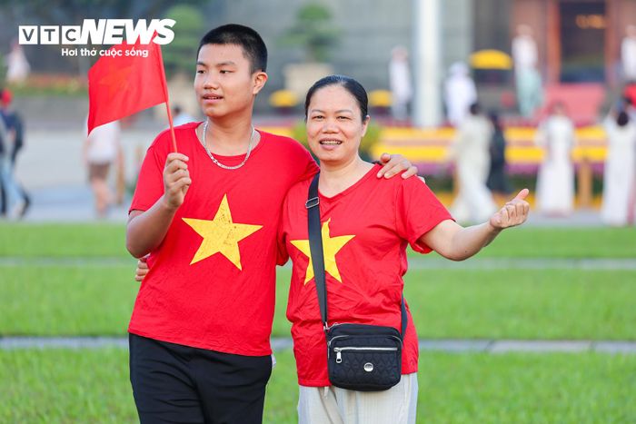 Trong khoảnh khắc Quốc kỳ tung bay, nhiều người dân giơ điện thoại ghi lại hình ảnh đáng nhớ. Các gia đình tranh thủ chụp ảnh bên nhau, lưu giữ những khoảnh khắc ý nghĩa tại Quảng trường Ba Đình.