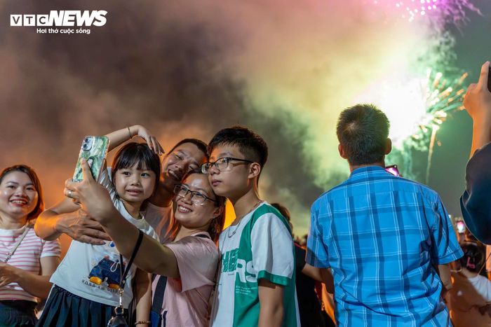 Người dân Hà Nội check-in, lưu giữ lại khoảnh khắc pháo hoa rực sáng tối 2/9/2025. 