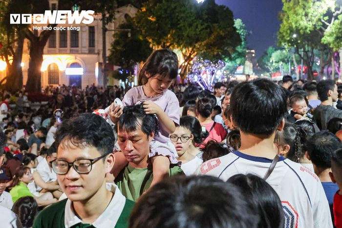 Không khí càng lúc càng náo nhiệt khi thời khắc khai hỏa đến gần. Các gia đình đưa theo trẻ nhỏ, nhiều em được bố mẹ bế hoặc cõng trên vai để vừa tránh dòng người chen chúc, vừa có thể quan sát rõ màn trình diễn.
