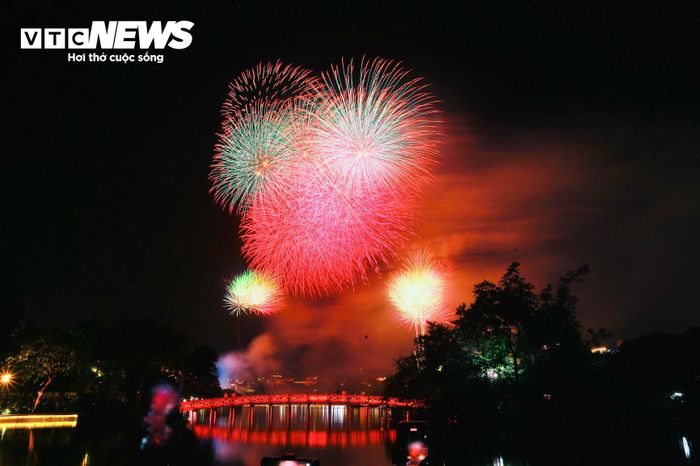Đúng 21h, tiếng đếm ngược vang lên giữa biển người. Những loạt pháo hoa đầu tiên vút lên rồi bung nở rực rỡ trên nền trời Hà Nội.