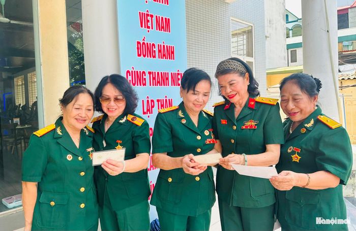 Các nữ chiến sĩ Đoàn văn công Trường Sơn cùng nhau xem lại những bức ảnh kỷ niệm. Ảnh: Bảo Lâm