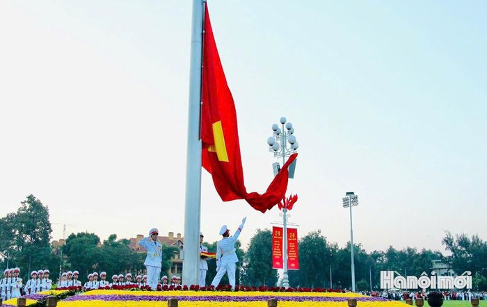 Lá quốc kỳ đỏ thắm với ngôi sao vàng năm cánh được tung lên. Ảnh: Bảo Lâm