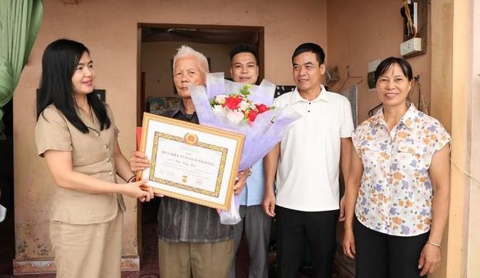 Phó Bí thư Thường trực Đảng ủy xã Tam Hưng Nguyễn Thị Bích Thuỷ thăm và trao tặng Huy hiệu Đảng đợt 2-9 cho đồng chí Cao Văn Lục, đảng viên 55 năm tuổi Đảng. Ảnh: Bình Minh 