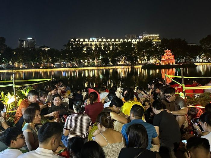 Người dân ngồi chờ xem pháo hoa. Ảnh: Hoàng Quyên