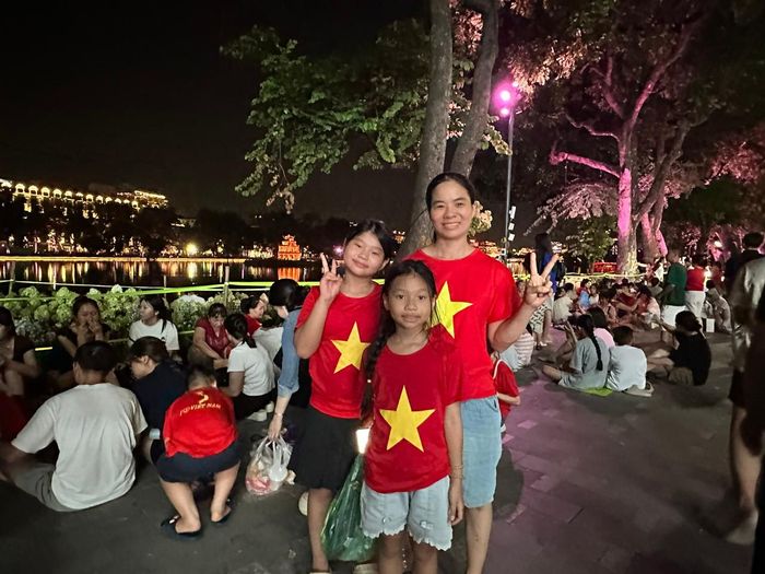Chị Ngô Thị Thương (Thanh Hóa) cùng hai con đã đến phố đi bộ hồ Hoàn Kiếm từ lúc 18h. Ảnh: Hoàng Quyên