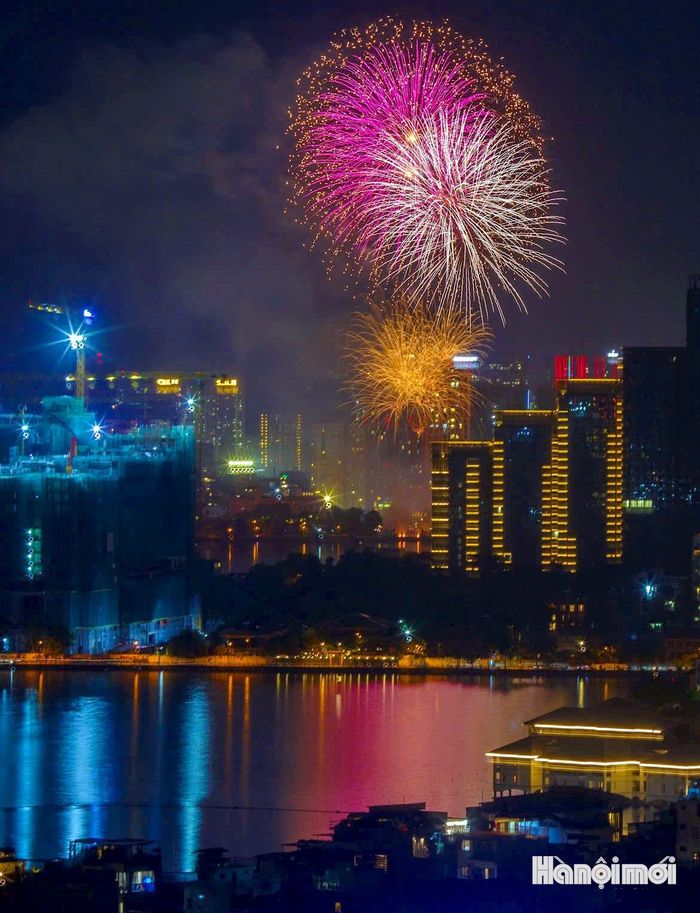 Pháo hoa đỏ, vàng, xanh bung nở như đóa hoa khổng lồ trên cao, phản chiếu xuống mặt hồ lấp lánh, hòa cùng tiếng reo hò của người dân.
