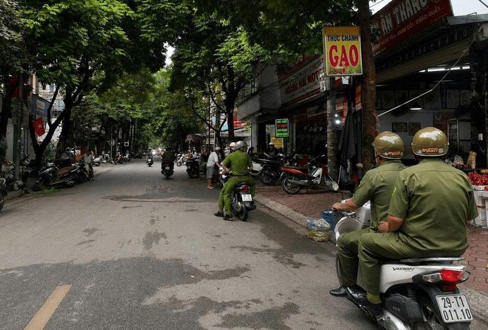 Công an phường Hà Đông tuyên truyền, nhắc nhở các hộ không lấn chiếm vỉa hè. Ảnh: Công an thành phố Hà Nội