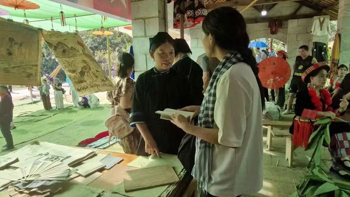 Chị Nông Thị Kính giới thiệu về sản phẩm giấy bản Dìa Trên tới du khách.