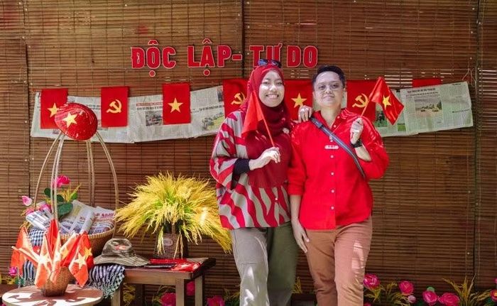 Du khách quốc tế thích thú check-in tại cùng quốc kỳ Việt Nam. Ảnh: TDC