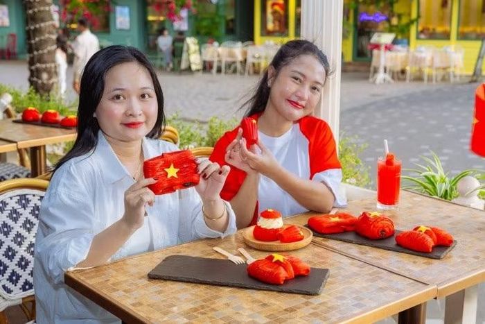 Du khách lưu lại khoảnh khắc “chạm tự hào” bên những chiếc bánh mang sắc cờ Việt Nam. Ảnh: TDC