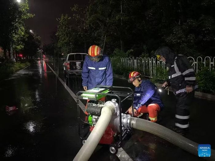 Công nhân đang bơm nước lũ trên một con đường ở thành phố Trương Châu, tỉnh Phúc Kiến ngày 3-9-2026