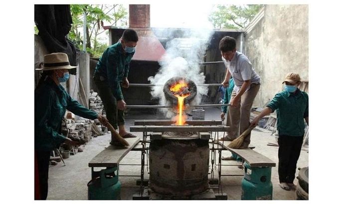 Nghệ nhân rót đồng nóng chảy vào trong khuôn đúc trống và trống đồng sau khi dỡ khuôn