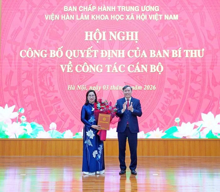 Ủy viên Ban Chấp hành Trung ương Đảng, Bí thư Đảng ủy, Chủ tịch Viện Hàn lâm Khoa học xã hội Việt Nam, GS.TS. Lê Văn Lợi trao Quyết định của Ban Bí thư và tặng hoa chúc mừng tân Phó Chủ tịch Viện Hàn lâm Khoa học xã hội Việt Nam Đinh Thị Mai