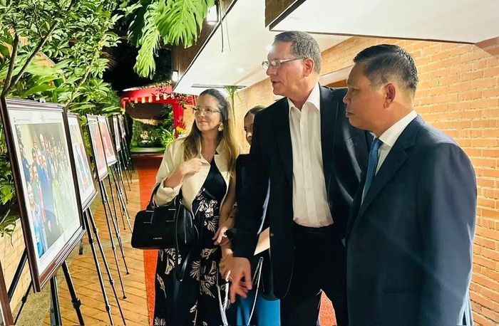 Đại sứ Vũ Trung Mỹ giới thiệu với các đại biểu về những hình ảnh quan hệ song phương Việt Nam-Venezuela được trưng bày tại Nhà Việt Nam ở thủ đô Caracas. (Ảnh: Đại sứ quán Việt Nam tại Venezuela cung cấp)