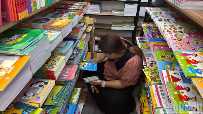 Phụ huynh cầm theo danh sách sách của từng lớp, lần lượt tìm kiếm giữa những dãy kệ.