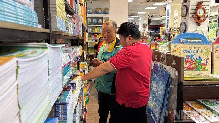 Nhân viên nhà sách hỗ trợ, kiểm tra thông tin hàng tồn khi phụ huynh hỏi mua một đầu sách đang thiếu.