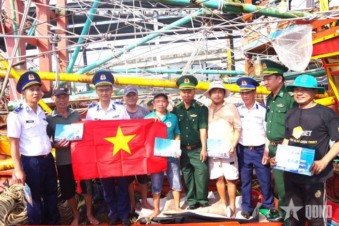 Hải đội 202 trao cờ Tổ quốc tặng các tàu cá đang neo đậu tại Cảng cá Cửa Việt (Quảng Trị).