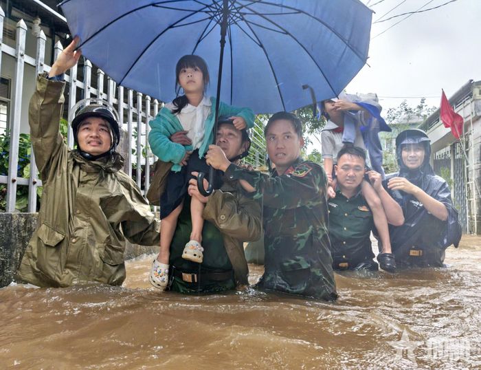 Cán bộ, nhân viên Ban CHQS phường Thống Nhất phối hợp đưa các cháu nhỏ đến nơi an toàn.
