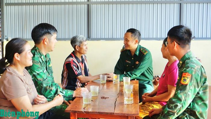 Cán bộ, chiến sĩ Bộ đội Biên phòng trao đổi với già làng Rơ Mah Blơih về công tác bảo vệ chủ quyền lãnh thổ, an ninh trật tự ở khu vực biên giới. Ảnh: NT