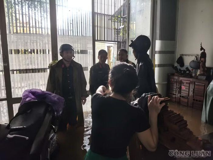 Lực lượng chức năng giúp người dân vùng ngập di chuyển đồ đạc, tài sản